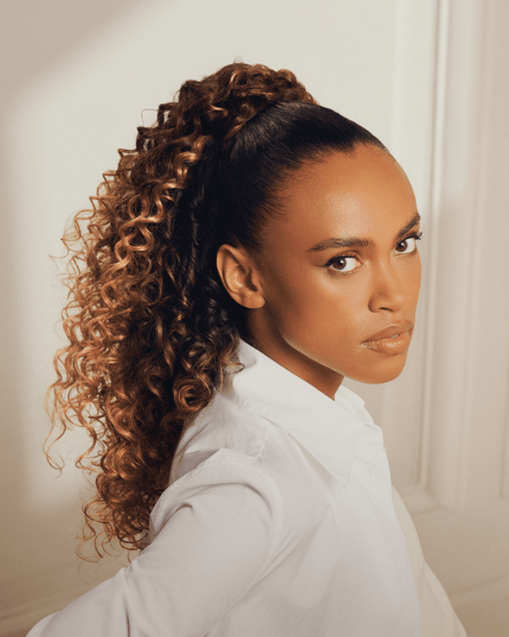 femme ponytail plaquée cheveux bouclés volume