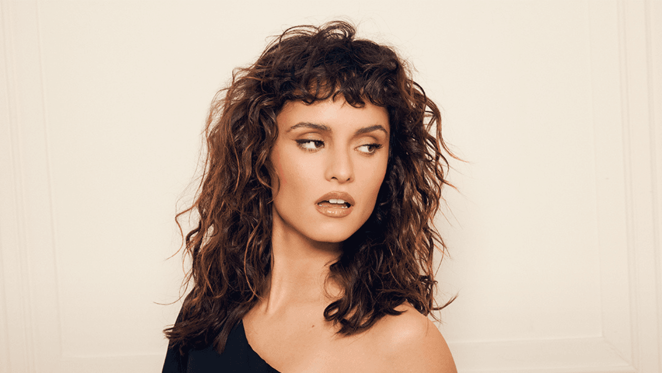 femme cheveux ondulés brun frange