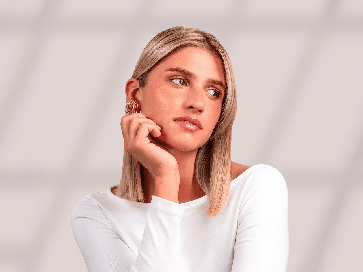 Portrait d'une femme aux cheveux blonds mi-longs, parfaitement lisses et lumineux, mettant en avant un résultat d'un soin botox capillaire.