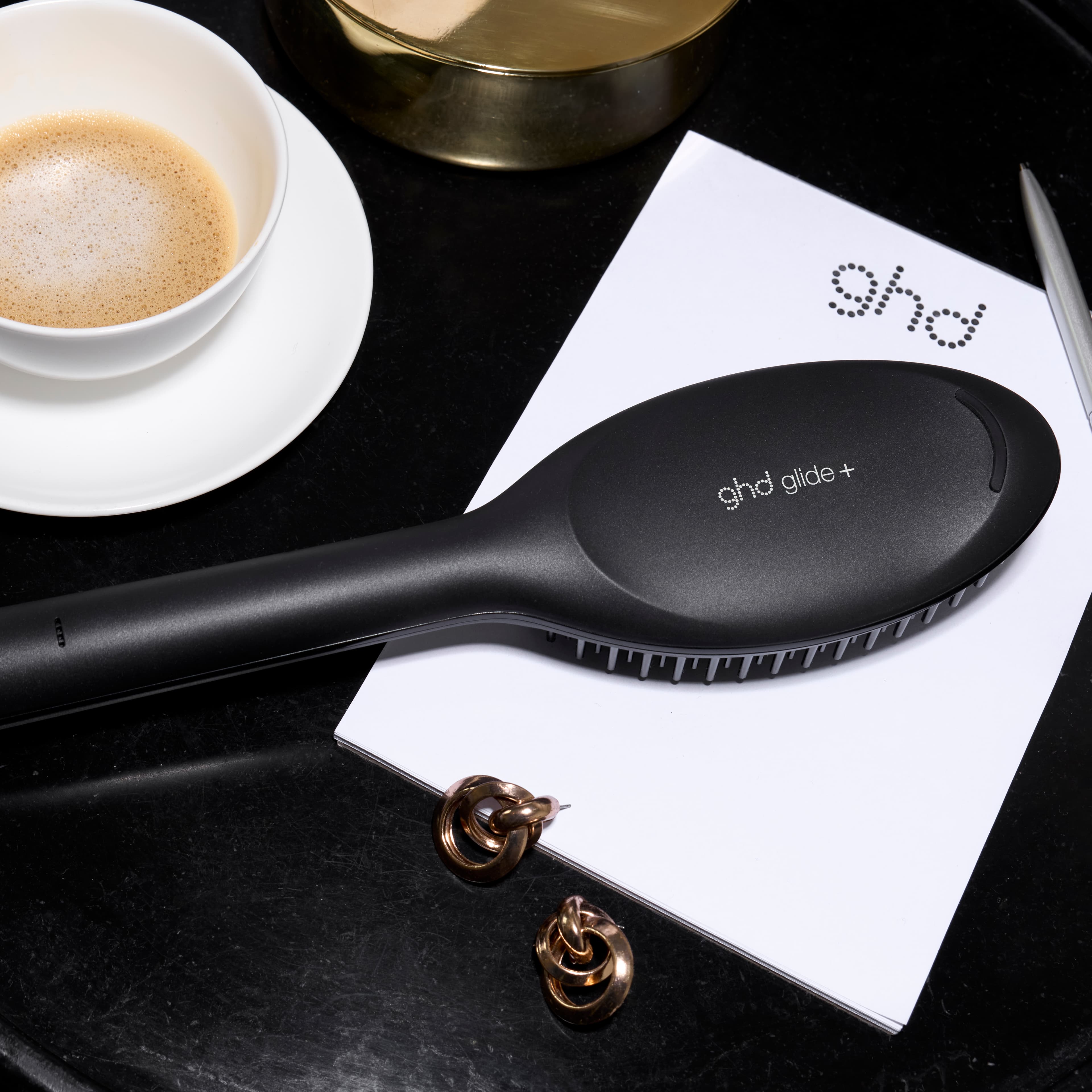 Brosse ghd glide+ posée sur une table